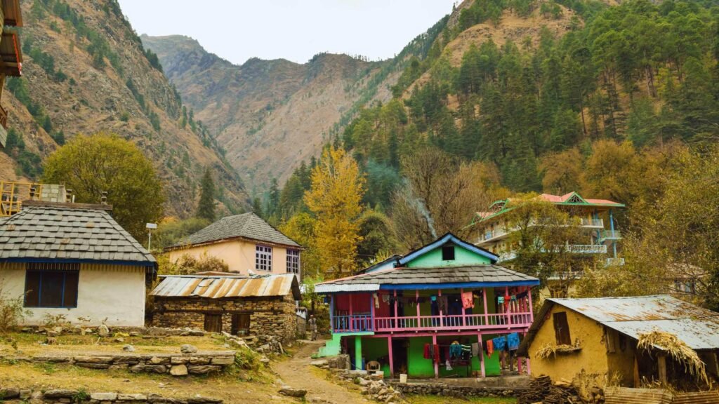 Chalal Village in Kasol showcasing wooden houses, green hills and calm Himalayan surroundings